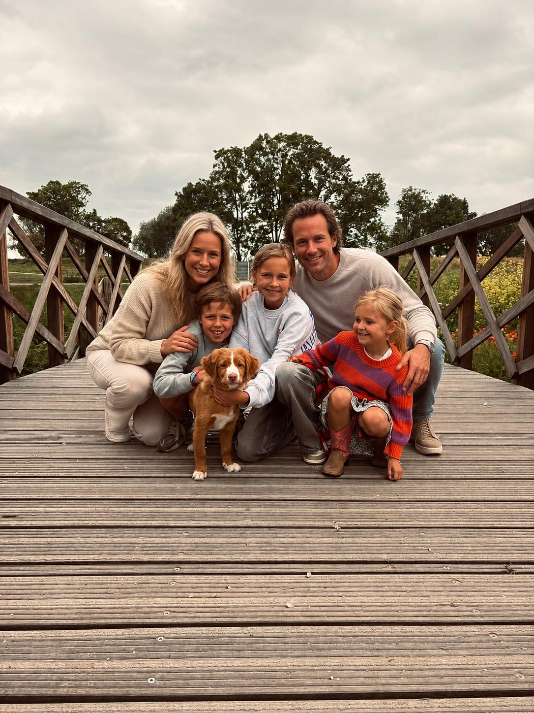 Gezin met hun puppy op een houten brug